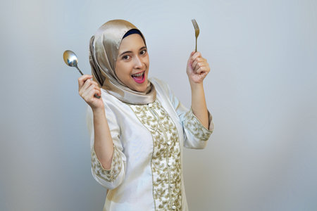 Indonesian muslim woman excitedly waiting for food after long day fasting diet during ramadanの写真素材