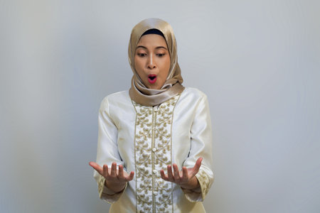 Indonesian Hijab Woman Surprised and Happy Holding a Gift concept. Celebrating Ramadan or Eid...