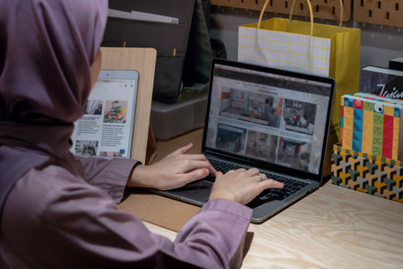 Hijab woman using laptop to do her homework. using laptop at home concept