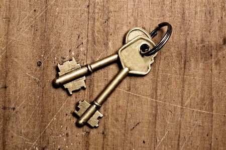 Bronze keys on wooden table.の写真素材