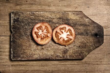 Tomatoes on old wooden table, studio shot.の写真素材