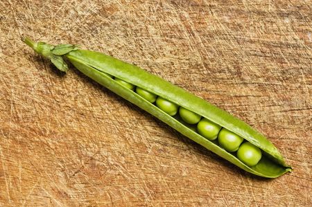 Fresh green peas on wooden background, studio shot.