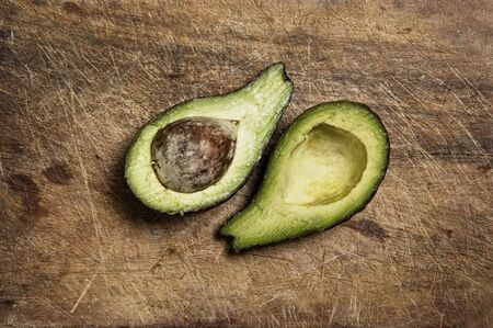 An avocado cut in two pieces.
