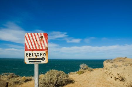 Old danger sign in the coast of patagonia, southern Argentina.の写真素材
