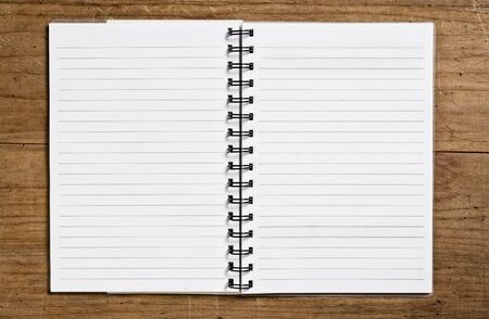 Open spiral notebook on wooden table.