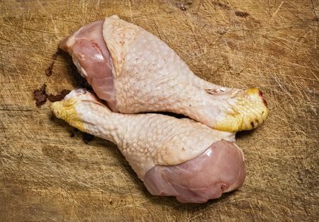Raw chicken legs on old wooden table.の写真素材