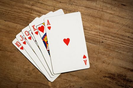 Rotyal flush poker hand on an old scratched table with copy space. Hearts.の写真素材