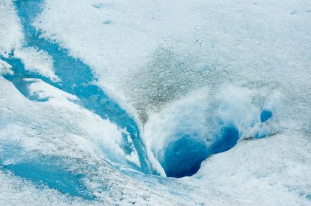 Hole in the ice carved by the water in the surface of Perito Moreno glacier, in Patagonia, Argentina.の写真素材