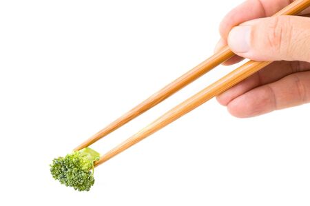 Chinese chopsticks with a piece of broccoli.の写真素材
