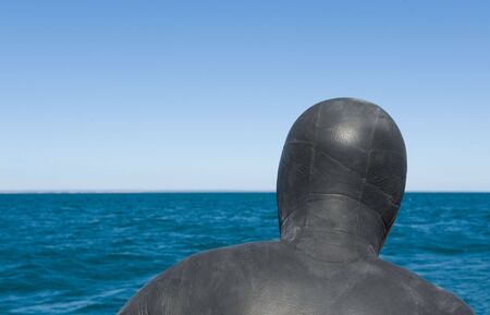 Diver in neoprene suit, looking at the horizon.の写真素材