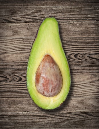 Avocado cut on wooden table, close up.の写真素材
