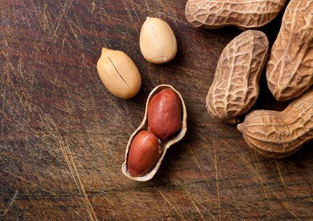 Bunch of peanuts on a wooden table.