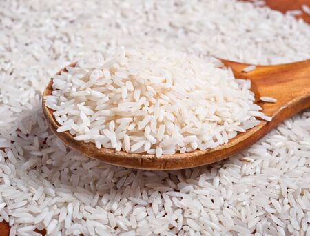 Rice background with wooden spoon.の写真素材
