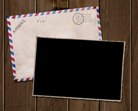 Old photo and envelope on wooden table.