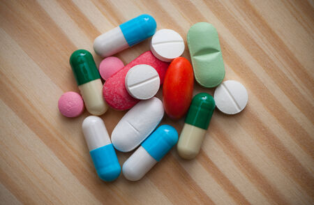 Pills on wooden background. Macro shot.