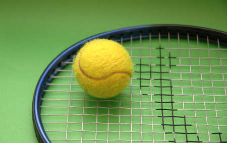 Tennis racket and ball on green backgroundの写真素材
