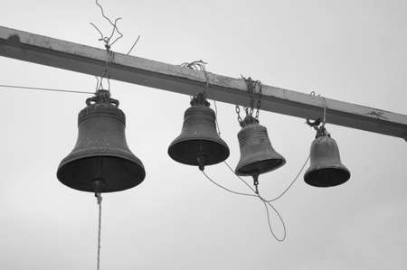 Four bells against a sky - black and white photoの写真素材