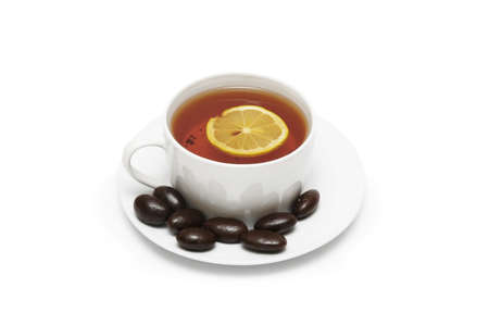 Cup of tea with lemon and chocolates isolated on whiteの写真素材