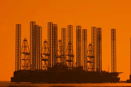 Offshore oil rig at shallow waters during sunsetの写真素材