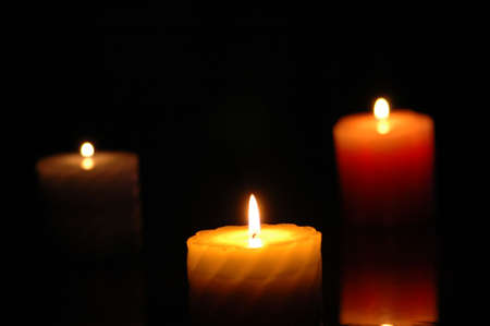 Three candles in the darkness - focus on the middle oneの写真素材