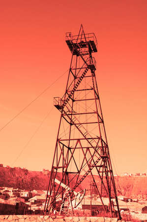 Oil derrick with "donkey" pump during sunsetの写真素材
