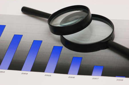 Studying business opportunities - magnifying glasses over the bar charts