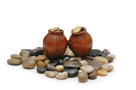 Two pots full of coin on pebblesの写真素材