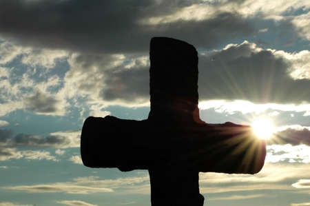 Silhouette of a cross  against evening sunの写真素材