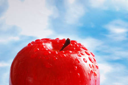 Apple with  water drops against the blue skyの写真素材
