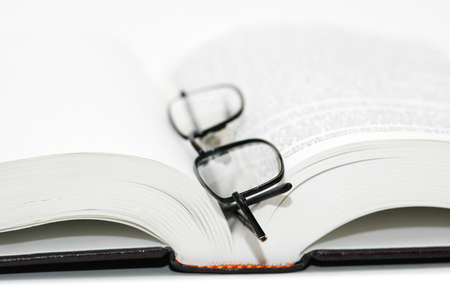 Reading glasses over the open textbook -  shallow DOF