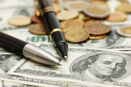 Two ballpens over the  hundred dollar banknotesの写真素材