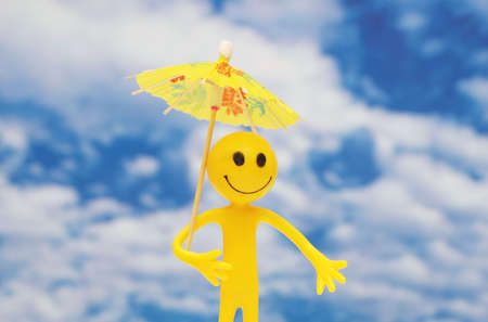 Smilie with yellow parasol  enjoying summer sun