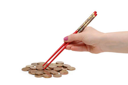 Hand with red chopsticks  eating golden coinsの写真素材