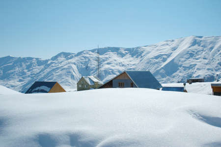High mountains and houses under snow in winterの写真素材