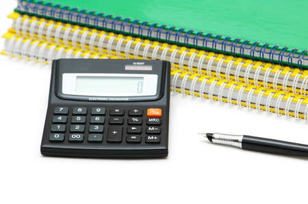 Calculator, spiral notebooks and pen isolated on whiteの写真素材
