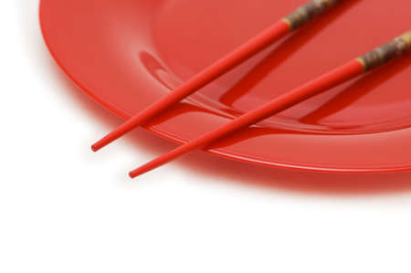 Red plate and chopsticks isolated on the whiteの写真素材