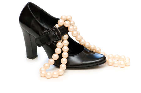Black shoe and pearl necklace isolated on whiteの写真素材