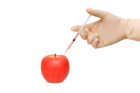 Hand with syringe and red apple on whiteの写真素材