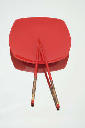 Red plate and chopsticks on reflective backgroundの写真素材