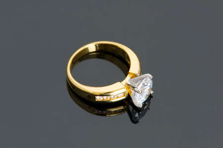 Gold diamond ring on the reflective backgroundの写真素材