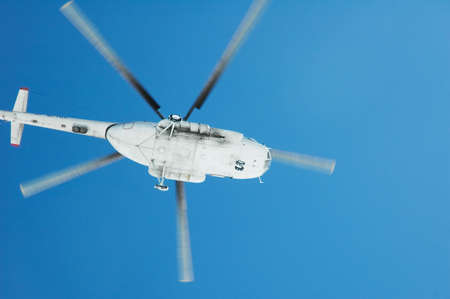 Flying helicopter against blue sky on bright day