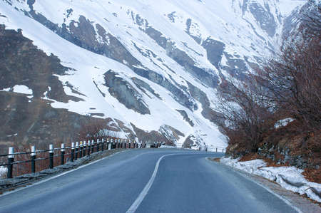 Empty road and mountains covered with snowの写真素材