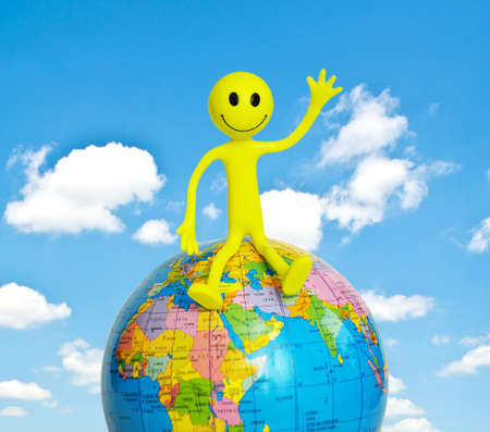 On top of the world - smilie sitting on the globeの写真素材