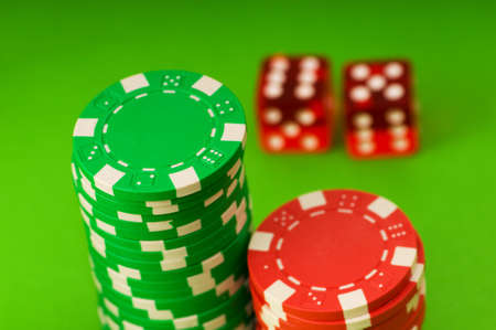 Casino chips and dice against green background