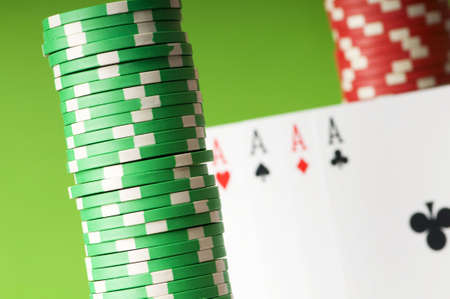 Casino chips and four aces against green background
