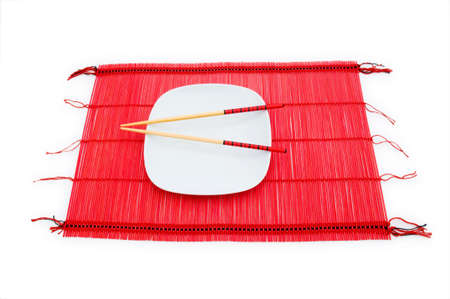 Chopsticks and plate on the bamboo matの写真素材