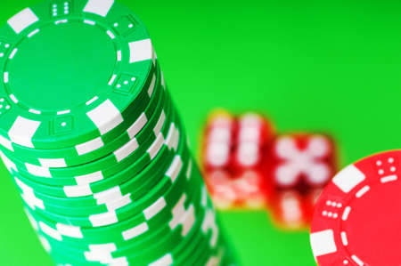 Casino chips and dice against green backgroundの写真素材