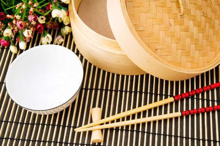 Chopsticks and bowl on the bamboo mat