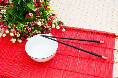 Chopsticks and bowl on the bamboo matの写真素材