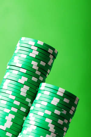 Stack of casino chips against green backgroundの写真素材